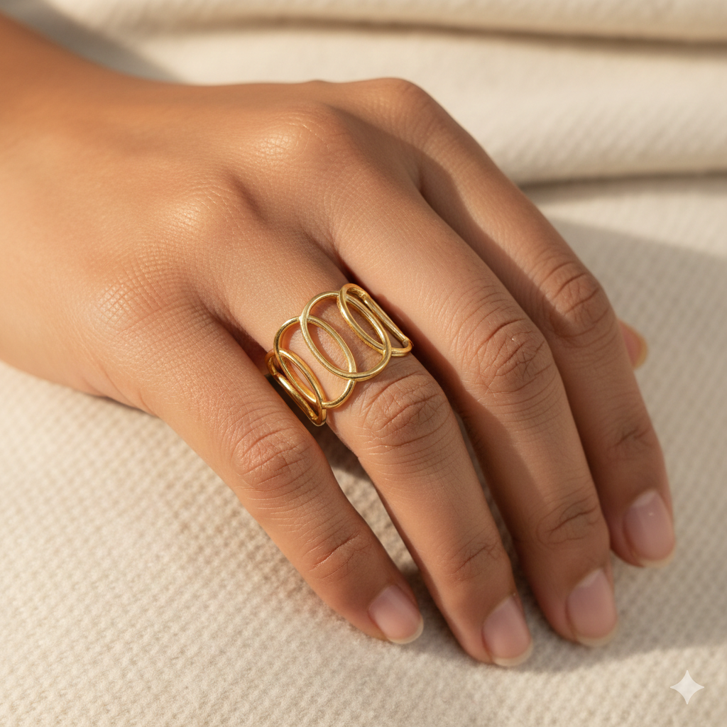 Gold ring on a person's finger against a neutral background
