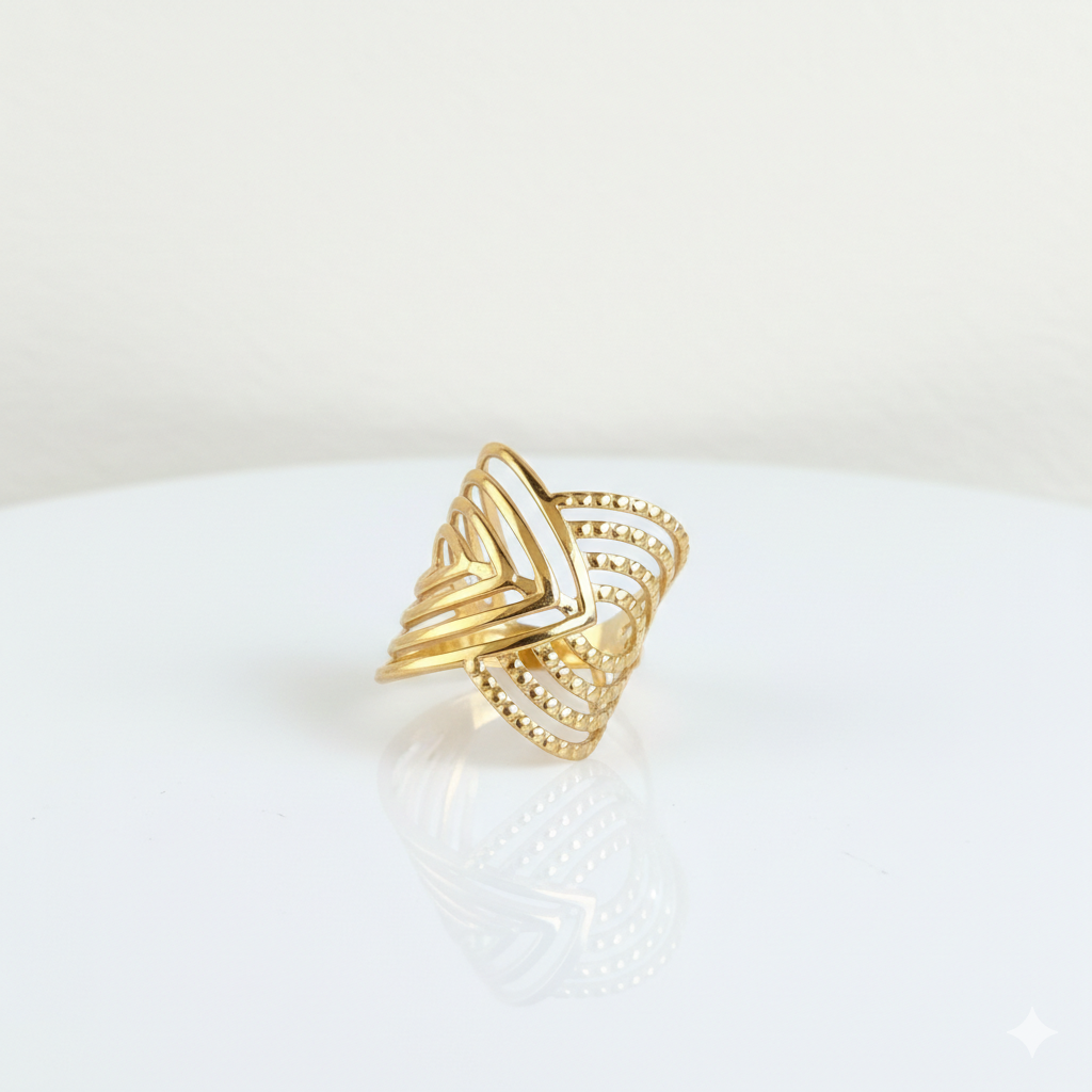 Gold ring with a geometric design on a white surface