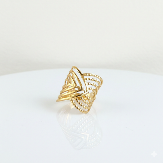 Gold ring with a geometric design on a white surface