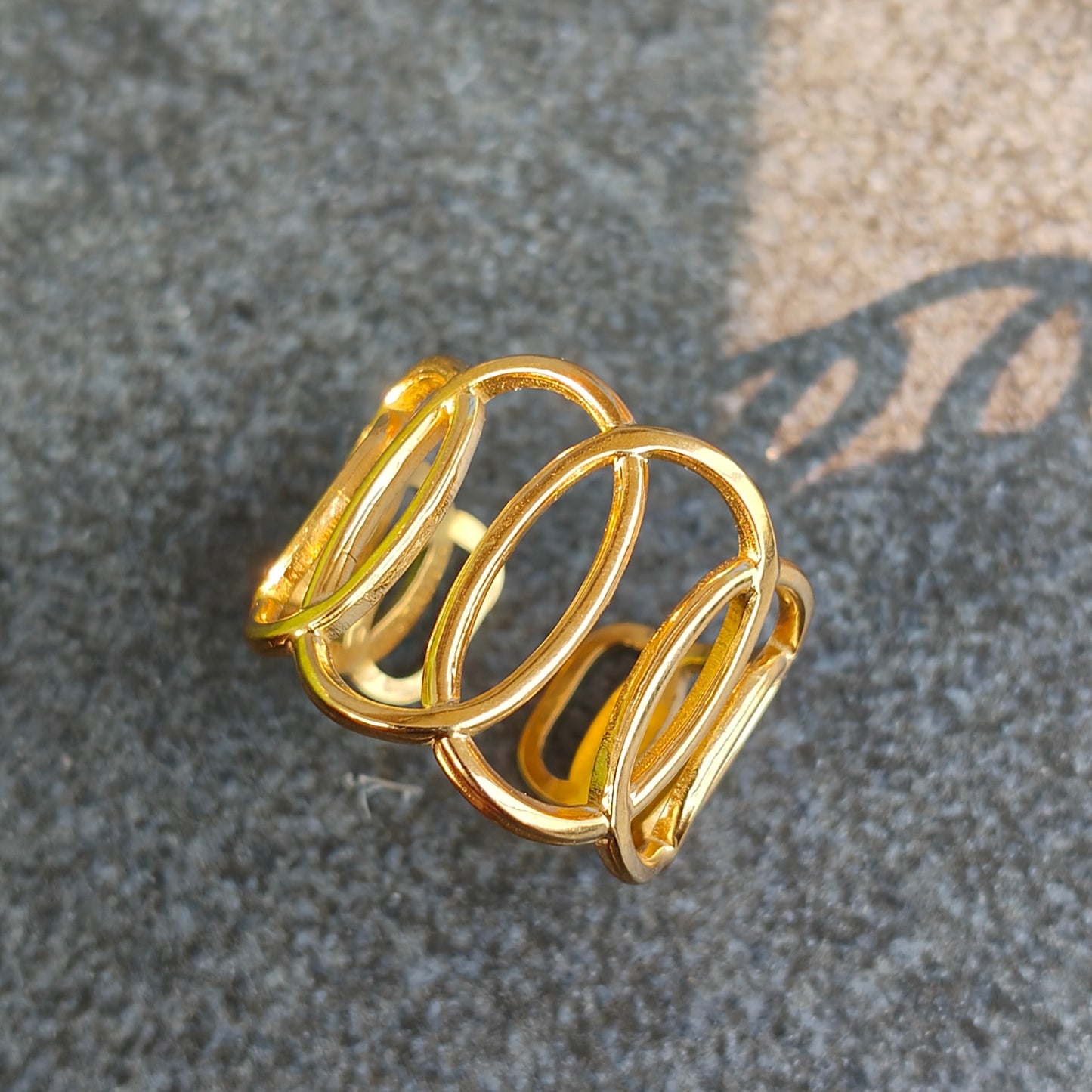 Gold spiral ring on a textured gray surface