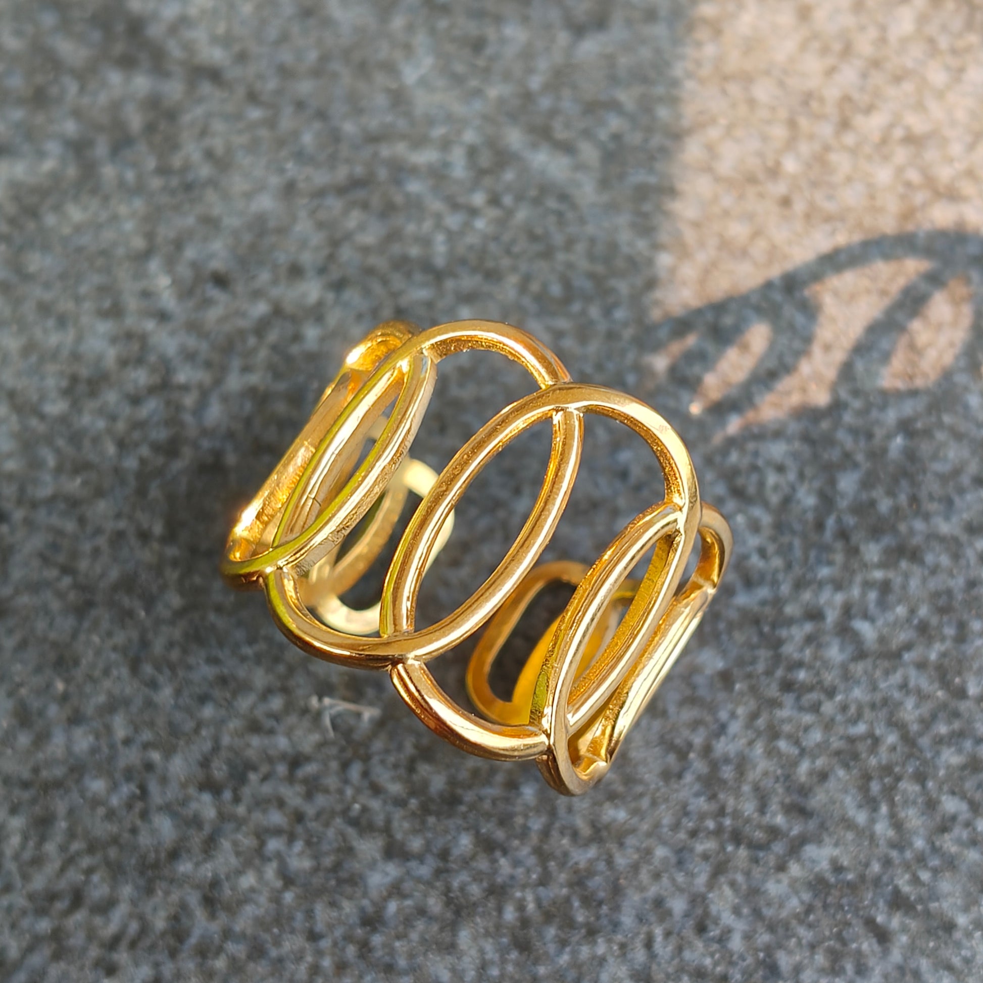 Gold spiral ring on a textured gray surface