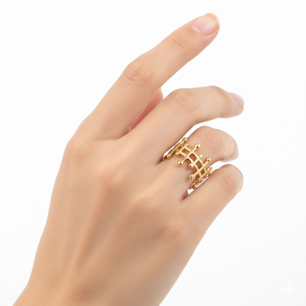 Hand wearing a gold ring with a geometric design on a white background